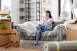 © Syda Productions - people, repair and real estate concept - happy smiling asian woman with stuff moving to new home