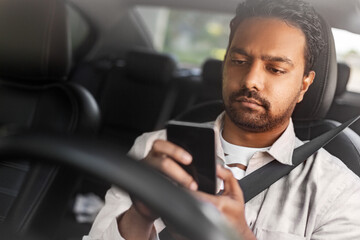 Wall Mural - transport, people and technology concept - indian man or driver using smartphone in car