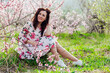 © dmitriisimakov - beautiful woman in a dress in the garden of flowering trees in the spring