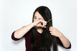 © AliciaFdez - Beautiful brunette woman cutting her long hair with scissors on a white background