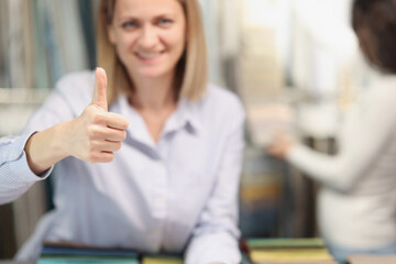 Wall Mural - Woman shopper smiling showing thumbs up gesture in store