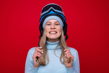 Wall Mural - Portrait of a smiling young woman in a sweater, helmet and ski goggles