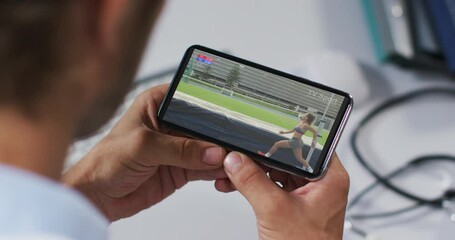 Sticker - Composite of male doctor watching athletics high jump event on smartphone