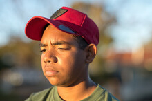 Head And Shoulders Of Surly Looking Teenager Wearing Cap
