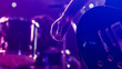 © Gorodenkoff - Rock Band Performing at a Concert in a Night Club. Close Up Shot of a Musician Holding and Dropping a Guitar Pick. Live Music Party in Front of Bright Colorful Strobing Lights on Stage.