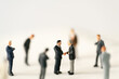 © BLUEBOEING - Miniature businessman shake hand partner client customers on stage with success dealing business using as contract commitment agreement investment and partnership business development joint venture