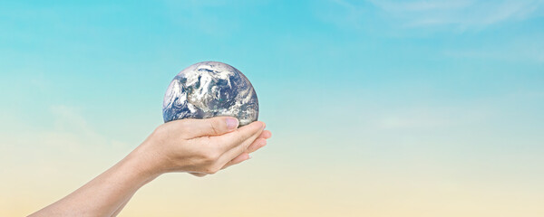 Canvas Print - globe in hands over blue sky background. save of earth. elements of this image furnished by nasa