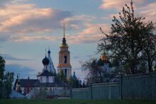 A Fence And Trees In Front Of A Church Against A Sky In Spring Evening
