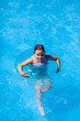 © Юля Бурмистрова - a happy girl swims in a swimming pool in an inflatable circle for safety on the water, with copy space.