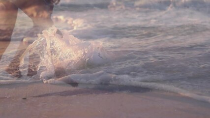 Wall Mural - Animation of bottle on beach over couple at beach splashing in sea