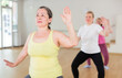 © JackF - Active senior females doing stretching workout before group dance training