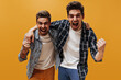 © Look! - Joyful emotional friends rejoice on orange background. Cool happy men in checkered shirts and white t-shirts laugh on isolated.