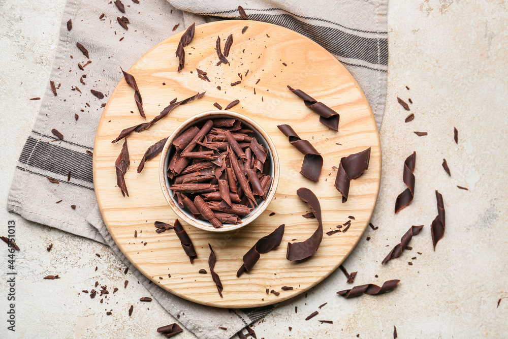Bowl with delicious chocolate curls on grunge background