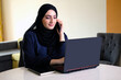 © Nordic Studio - Arab working remotely from home. Emirati national at work. Woman wearing Abaya Hijab