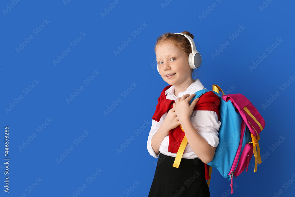Cute little schoolgirl on color background