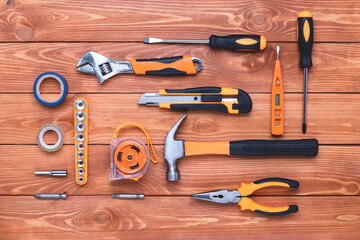 Set of construction tools on a brown wooden background. Hammer, wrench, pliers and screwdriver. Gift card for the holiday Labour Day. Equipment, workplace. DIY concept. Flat lay. Overhead view.