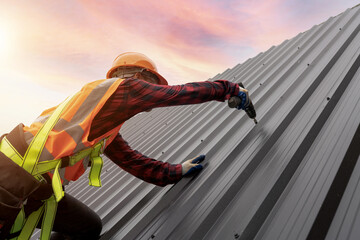 Roofer installing metal sheet on the house structural work