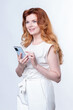 © PaulShlykov - Redhead woman with a large smartphone in her hands