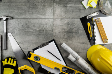 Sticker - Contractor theme. Plans, tool kit of the contractor, yellow hardhat and libella. Gray tiles background.