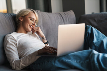 Wall Mural - Smiling mid aged blonde woman studying online