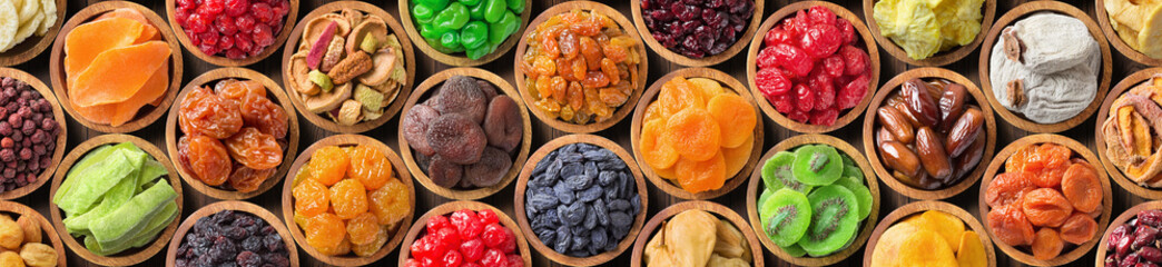 Wall Mural - various dried fruits and berries in bowls, top view. panoramic food background.