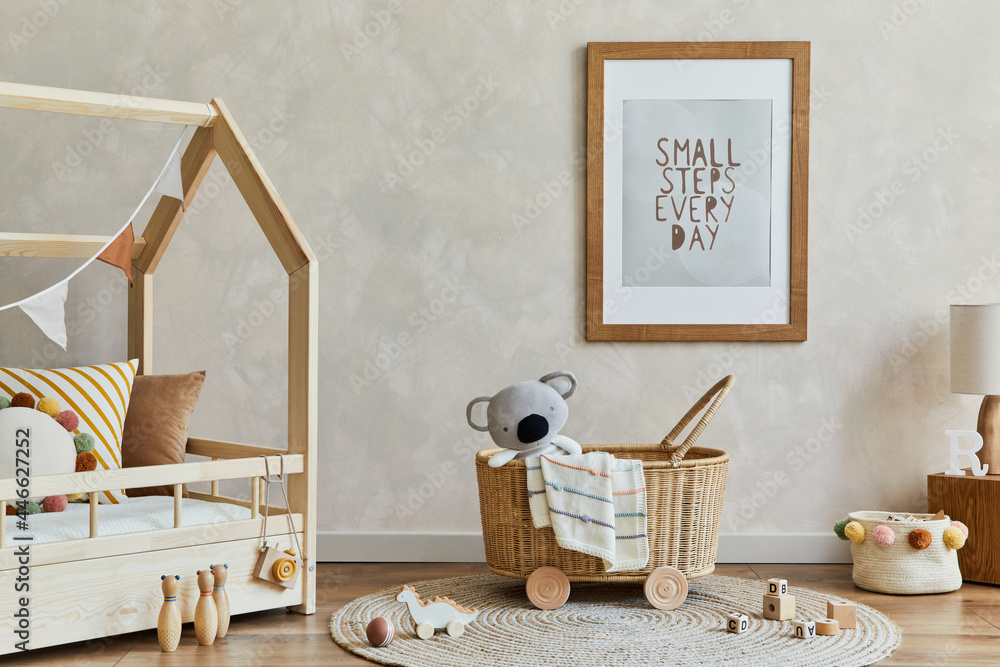 Stylish composition of cozy scandi child's room interior with mock up poster frame, bed, rattan basket, plush and wooden toys and decorations. Creative wall, carpet on the floor. Copy space.  - obrazy, fototapety, plakaty 