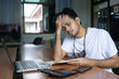 © anut21ng Stock - Asian man suffering from headache after computer work male massaging head feeling stress, fatigue or migraine using laptop at home office