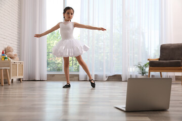 Wall Mural - Cute little girl taking online dance class at home