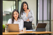 © David - Two beautiful asian business Female smiling happy and confident. Sitting with smile on face working together using laptop at the office
