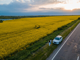 Sticker - couple stop at roadside of speedway looking on yellow field on sunset