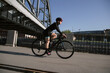 © Алексей Васильев - A cyclist trains in the morning in the city on the waterfront. Cycling in the city. Preparing for the competition.