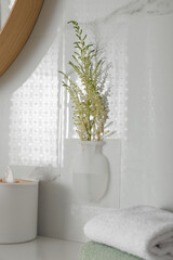 Poster - Silicone vase with flowers on white marble wall over countertop in bathroom