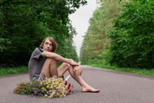 A Young Guy With Flowers On A Forest Road