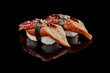 Two nigiri sushi with eel, unagi sauce and sesame