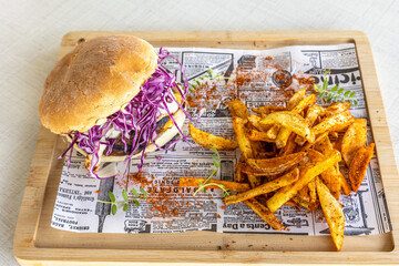 Poster - High-angle shot of fresh and tasty burger with french fries on a wooden board