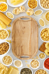 Poster - Pasta. Various kinds of uncooked pasta and noodles over stone background, top view with copy space for text. Italian food culinary concept. Collection of different raw pasta on cooking table