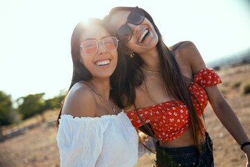 Two smiling young women talking anad laughing while enjoying summer on road trip.