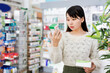 © JackF - Young cheerful positive chinese female customer looking for right medicine in pharmaceutical store