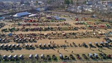 An Aerial View Of An Amish Mud Sale With Buggies, Farm Equipment And Other Crafts In Early Spring