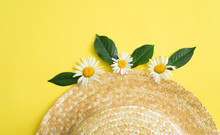 Straw Hat With Daisies On A Yellow Background