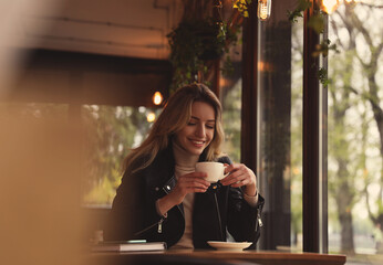 Canvas Print - Young woman with cup of coffee at cafe in morning