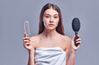 © Olena Apetroaiei - Portrait of a beautiful attractive cute well-groomed lady holding a comb in her hand, smooth, soft, silky hair, keratin effect, isolated on gray background.