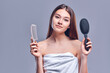 © Olena Apetroaiei - Portrait of a beautiful attractive cute well-groomed lady holding a comb in her hand, smooth, soft, silky hair, keratin effect, isolated on gray background.