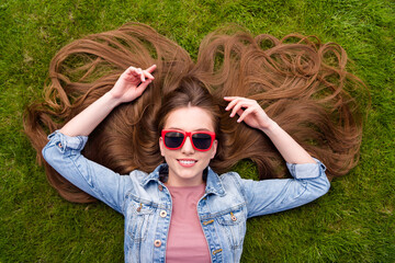 Poster - Top above high angle view portrait of attractive cheerful girl lying on green grass resting holiday outdoor fresh air