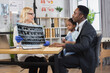 © sofiko14 - Friendly qualified pleasant blond woman doctor holding x-ray scan, talking with handsome caring black-skinned father with small cute mixed race daughter on knees, during visit to clinic
