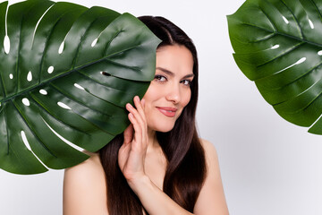 Wall Mural - Photo portrait woman hiding behind green leaves nude shoulders isolated white color background