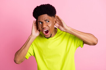 Poster - Photo of young african guy amazed shocked hands touch ears eavesdrop news rumor look empty space isolated over pink color background