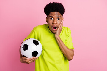 Poster - Photo of young african guy amazed shocked surprised hand touch cheek hold soccer ball goal isolated over pink color background