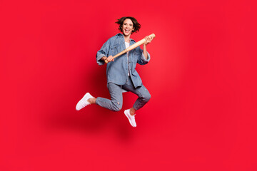 Poster - Full length photo of young woman happy positive smile hold baseball bat jump isolated over red color background