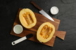 Flat lay composition with halves of fresh spaghetti squash on black table. Cooking vegetarian dish